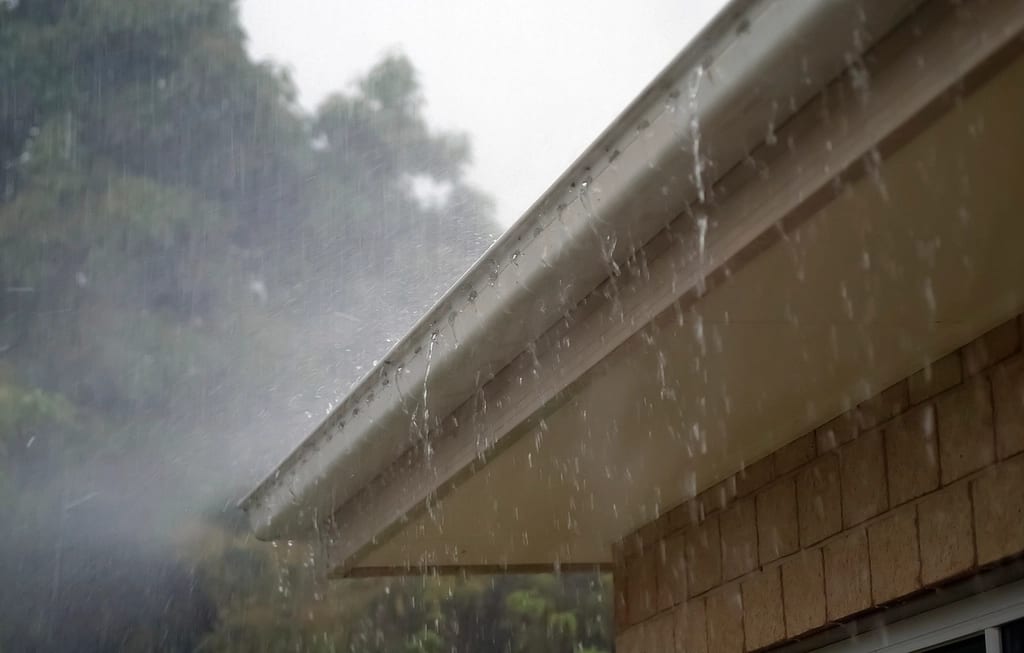 Rain overflowing a clogged gutter on a Washington DC area home
