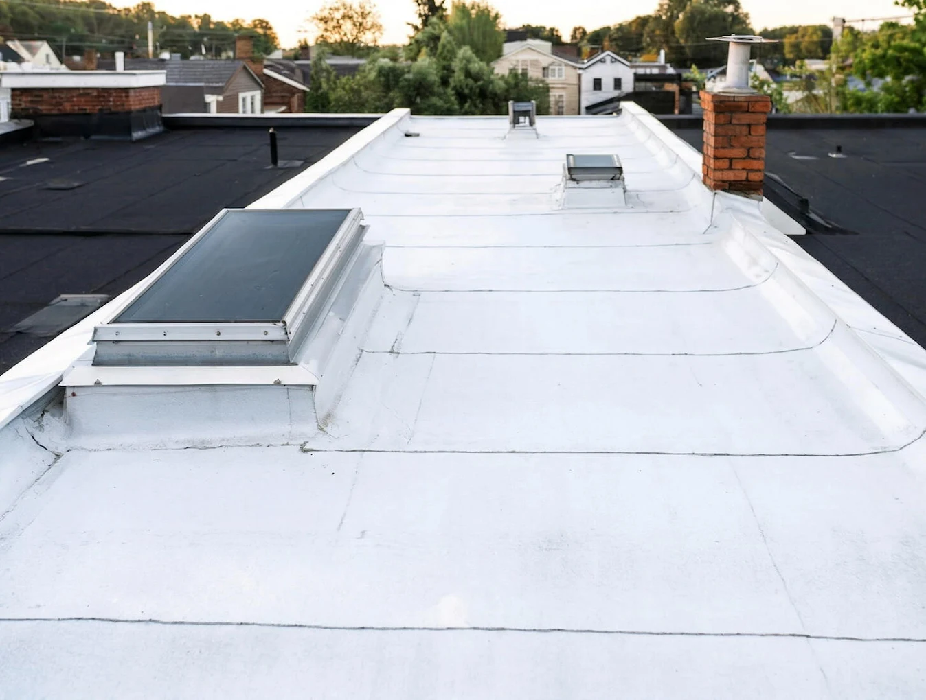New flat roof membrane with skylights and brick chimney on a Washington DC rowhouse