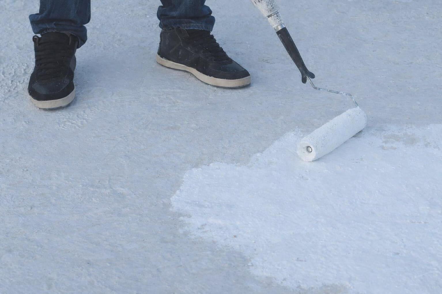 Roof coating application with a roller on a flat roof